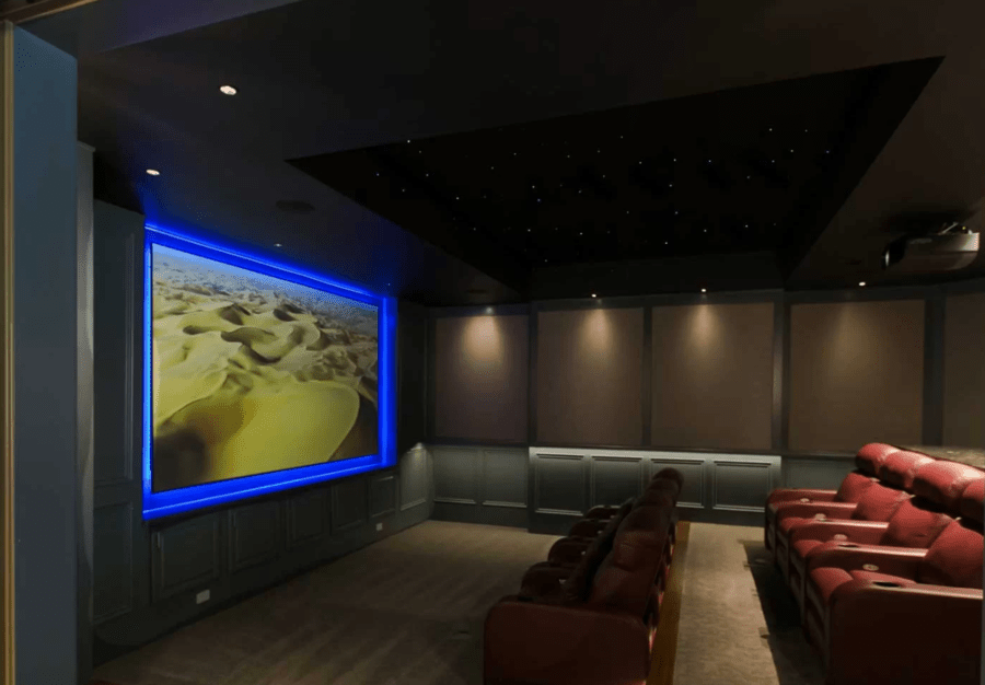 A dedicated home theater featuring red recliners and a starry night ceiling. 