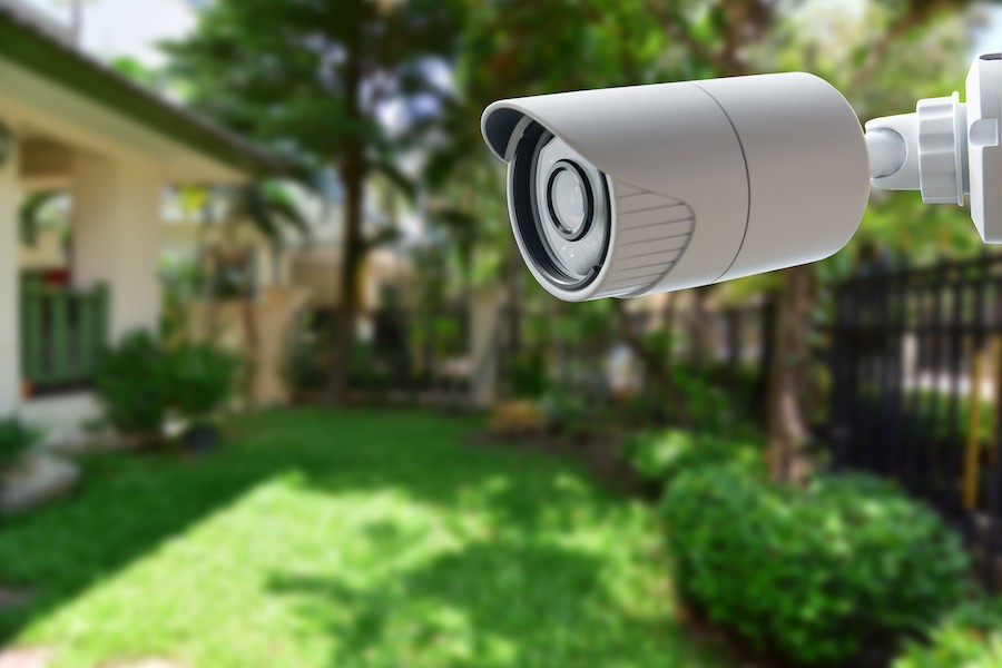 A security camera mounted outside a house, monitoring the surroundings.