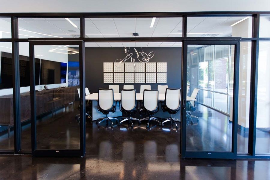 A modern conference room with two displays and in-ceiling speakers.