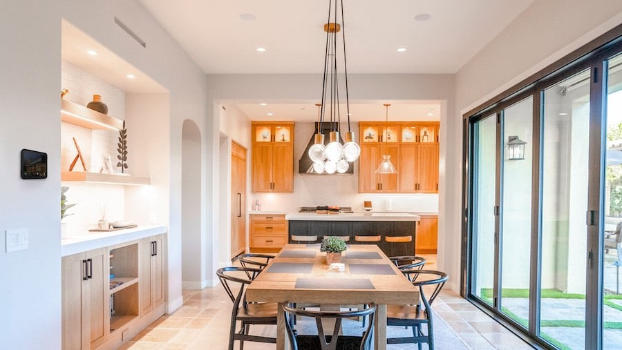 A kitchen with patio sliding doors and a technology control panel on the wall.