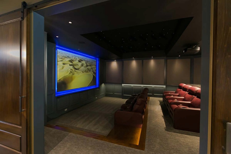 A home theater featuring red leather chairs. 